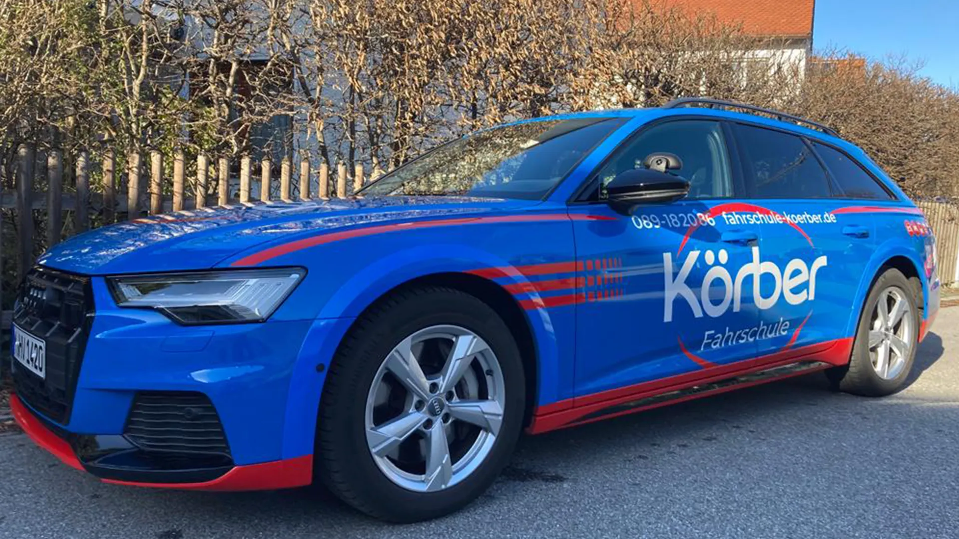 Blauer Audi-Kombi mit Körber-Beschriftung und zusätzlichen Fahrschulspiegeln
